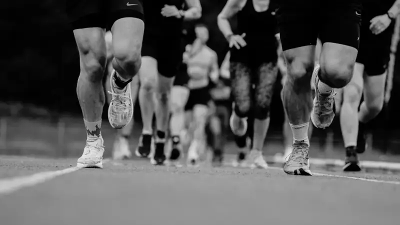 Athletes running on the track at a Deadly Dozen race
