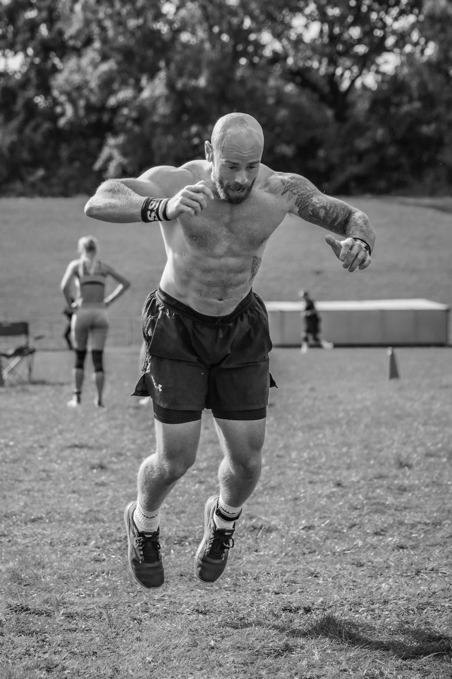 Athlet mitten im Burpee Broad Jump in der 30m-Bahn