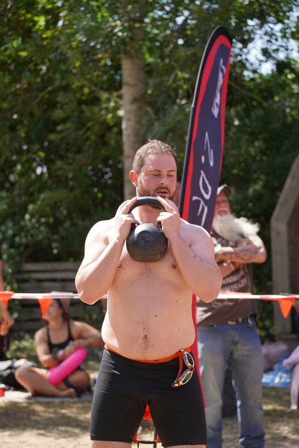 A Deadly Swim racer lifting a kettlebell between swims