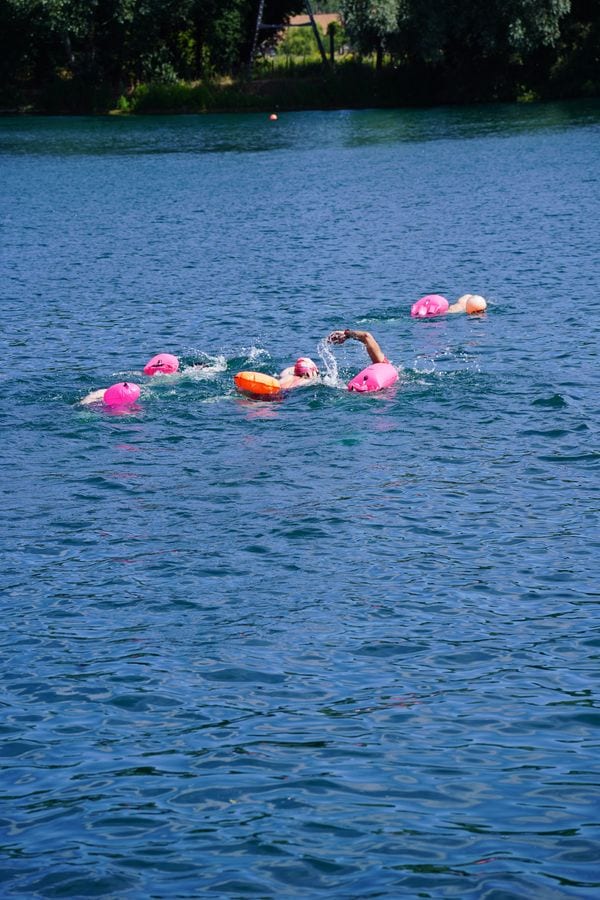 Deadly Swim racers swimming in open water with pink tow floats
